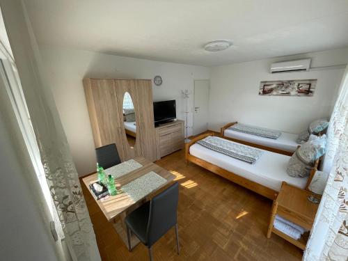 Kleines Zimmer mit 2 Betten und einem Schreibtisch. in der Unterkunft Nita in Frickenhausen