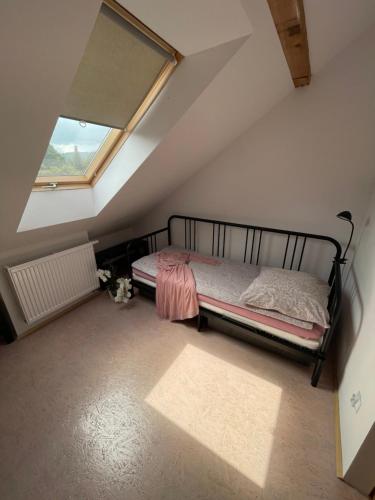 a bedroom with a bed in a attic with a window at Dom Coacha i Mentora in Wysowa-Zdrój
