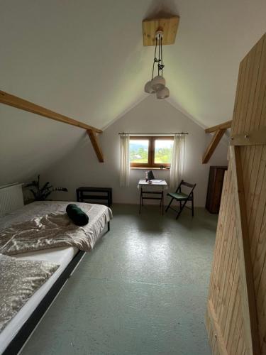 Schlafzimmer mit einem Bett, einem Tisch und einem Fenster in der Unterkunft Dom Coacha i Mentora in Wysowa-Zdrój