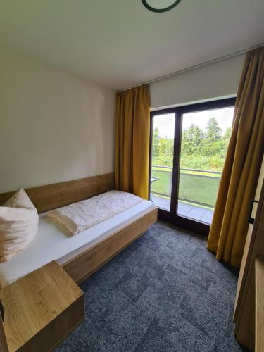 a bedroom with a bed and a large window at Gästehaus Weber in Rodgau