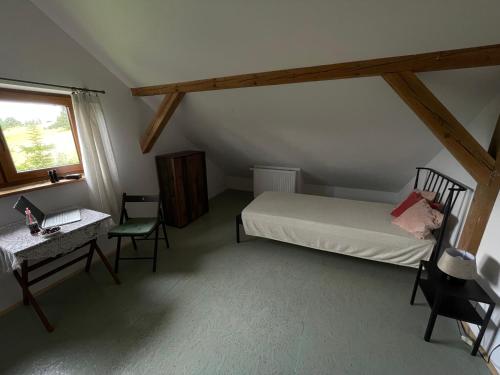 a bedroom with a bed and a desk and a window at Dom Coacha i Mentora in Wysowa-Zdrój