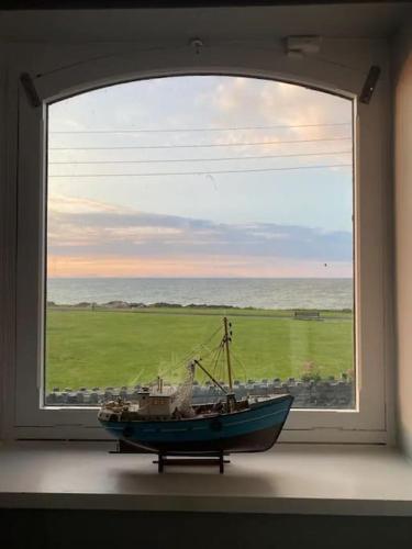 una piccola barca seduta all'interno di una finestra di The Anchor a Skerries