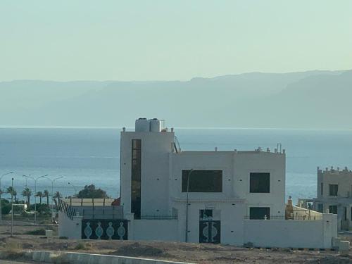 a white building with the ocean in the background at Sea view in Al Burj