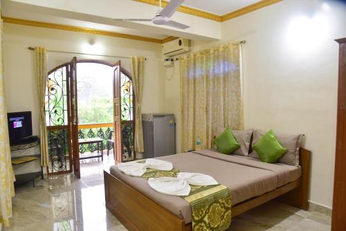 a bedroom with a bed and a tv and a window at ULTIMATE STAY in Calangute