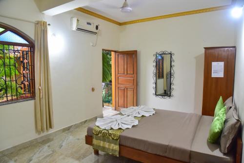 a bedroom with a bed in a room with a door at ULTIMATE STAY in Calangute
