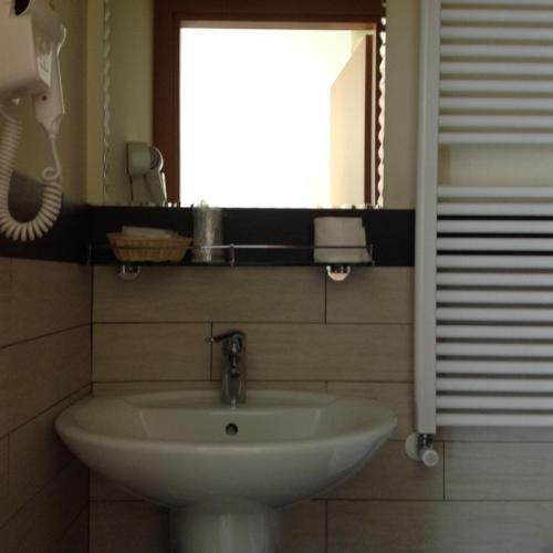 a bathroom with a sink and a mirror and a window at Hotel Okinawa in Rimini