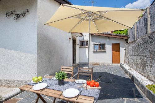 a table with an umbrella and some fruit on it at Casa Elvezia - Happy Rentals in Piandera