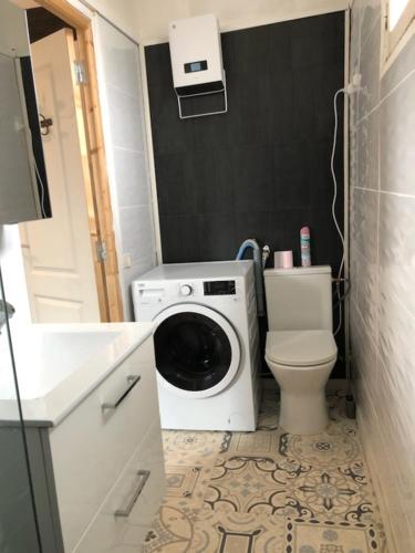 ein Badezimmer mit einer Waschmaschine und einem WC in der Unterkunft Appartement à 15min de la mer in Montblanc