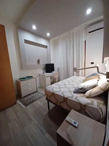 una camera con letto e scrivania con TV di Gardenia free parking a Bari