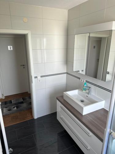 ein Badezimmer mit einem weißen Waschbecken und einem Spiegel in der Unterkunft Nita in Frickenhausen