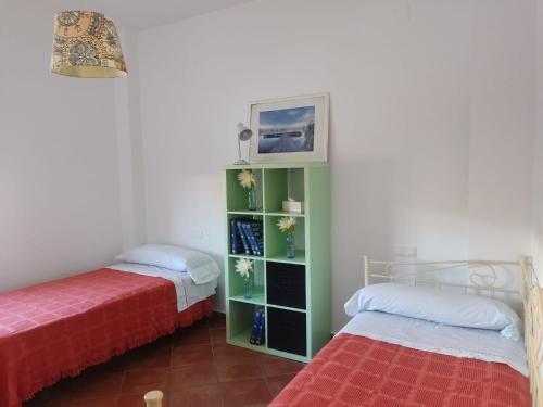 1 dormitorio con 2 camas y una estantería verde en Preciosa casa de pueblo “La fontita 5”, en Villablanca