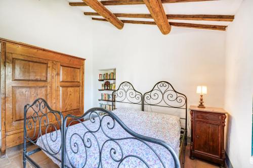 a bedroom with a metal bed and a wooden cabinet at Semidetached Villa Shared Pool - Happy Rentals in Colle