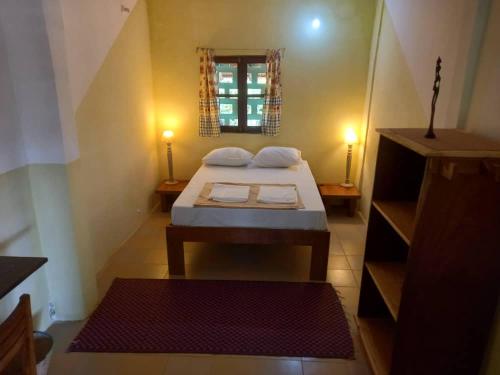 a small room with a bed and a window at KONE-METTLER GUEST HOUSE in Abémé