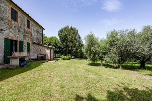 an old stone building with a yard and trees at Semidetached Villa Shared Pool - Happy Rentals in Colle