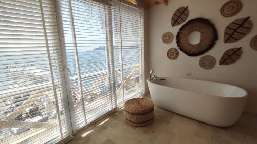 a bathroom with a tub in front of a large window at The Roof Ada in Adalar