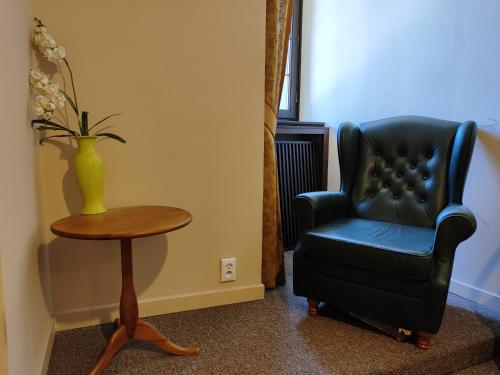czarne krzesło, stół i wazon z kwiatami w obiekcie Pokój jednoosobowy z prywatną łazienką - Piotrkowska 262-264 pok 302 w Łodzi