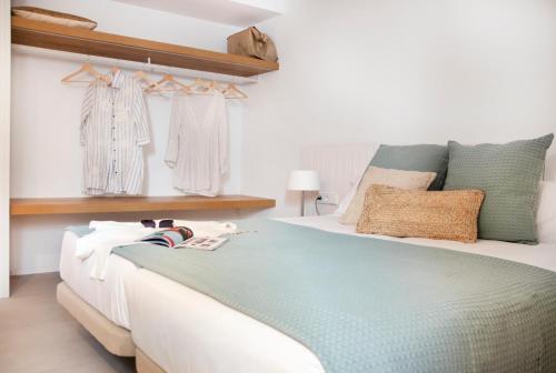 1 dormitorio con 1 cama grande y toallas. en Pinomar - Emar Hotels, en Es Caló