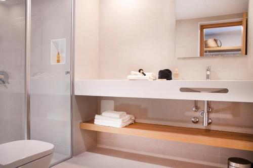 a bathroom with a sink and a toilet and a shower at Pinomar - Emar Hotels in Es Caló