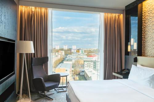 a hotel room with a bed and a large window at Hilton Tallinn Park in Tallinn