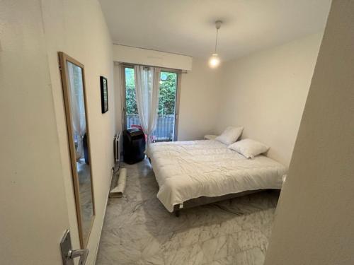 une petite chambre avec un lit et une fenêtre dans l'établissement Appartement Cosy Montpellier, à Montpellier