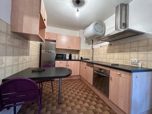 a kitchen with a table and purple chairs in it at Appartement Cosy Montpellier in Montpellier