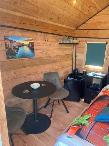 Zimmer mit einem Tisch und einem TV in einer Hütte in der Unterkunft Hoogte Huisje Italien in Swalmen