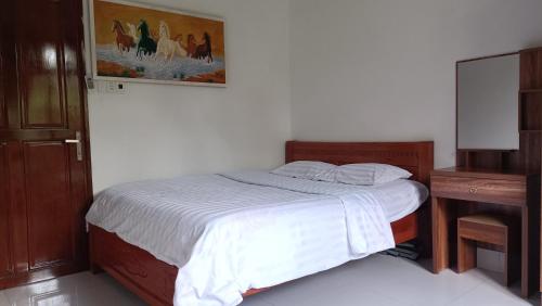 - une chambre avec un lit et une peinture murale dans l'établissement HOMESTAY HT, à Vĩnh Long