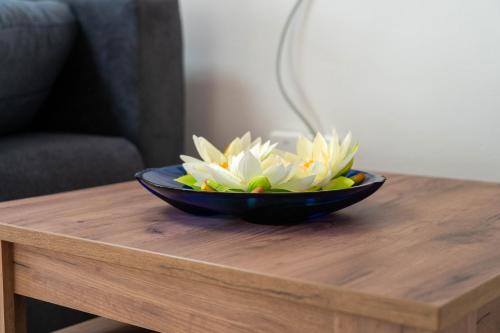 a black bowl with flowers on a wooden table at LOFT 2 in Thürnthal