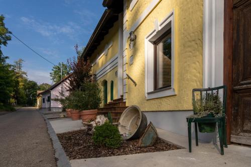 un bâtiment jaune avec une fenêtre sur une rue dans l'établissement LOFT 2, à Thürnthal