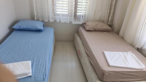 two beds in a small room with a window at merkez konumda in Gokceada Town