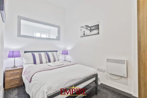 Habitación blanca con cama y espejo en Modern One Bedroom Apartment Brierley Hill, en Brierley Hill