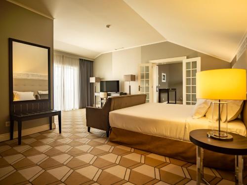 une chambre d'hôtel avec un lit et un salon dans l'établissement Hotel Do Colegio, à Ponta Delgada