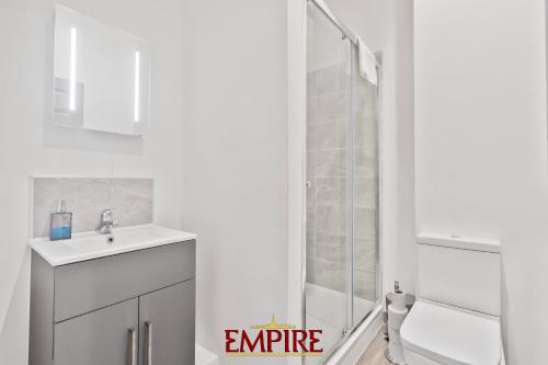 a white bathroom with a shower and a sink at Modern One Bedroom Apartment Brierley Hill in Brierley Hill