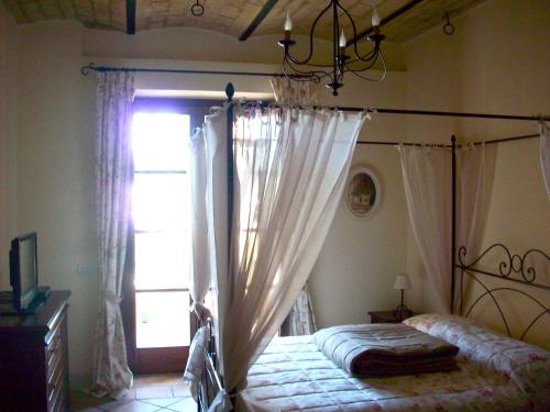 a bedroom with a canopy bed and a window at Residenza Porta Guelfa in Bevagna