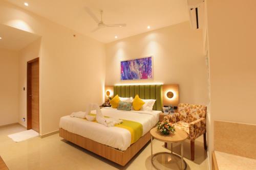a hotel room with a bed and a chair at THE GRAND AMBASSADOR HOTEL in Kottayam