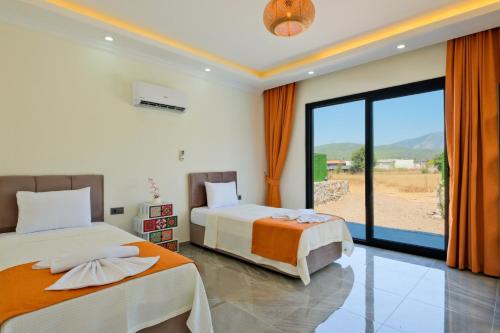 a bedroom with two beds and a large window at Villa Sincap in Fethiye