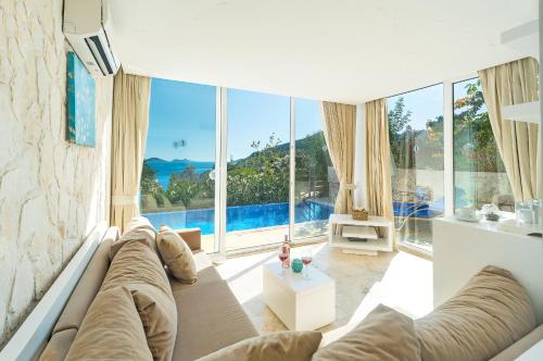 a living room with a couch and large windows at Likya Pavilion Hotel in Kas