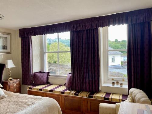 a window seat in a bedroom with a large window at Elim in Dartmouth with stunning River Dart view in Dartmouth
