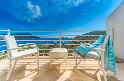 a balcony with two chairs and a view of the ocean at Likya Pavilion Hotel in Kas