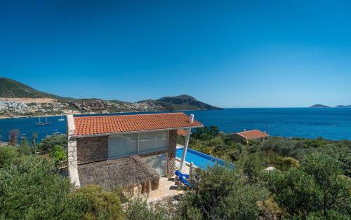 a house with a swimming pool and the ocean at Likya Pavilion Hotel in Kas