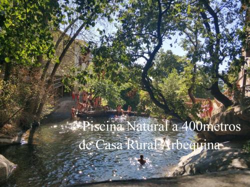 a river in a park with people in the water at Casa Rural Arbequina - Naturaleza y Calma en el Valle del Ambroz in Casas del Monte
