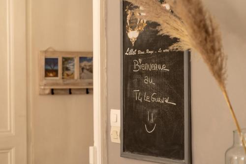 a chalkboard sign on a wall next to a door at Centre-ville ~ Wi-Fi ~ Netflix ~ T4 LE GURVAL in Guer