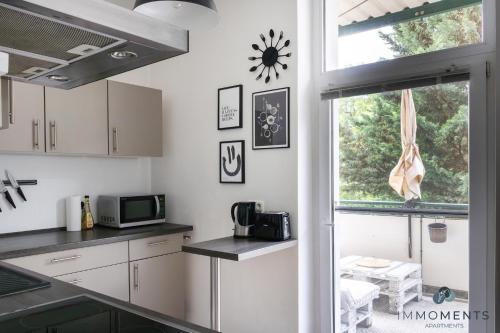 uma cozinha com armários brancos e uma janela em Stilvolles Apartment im Zentrum em Magdeburg