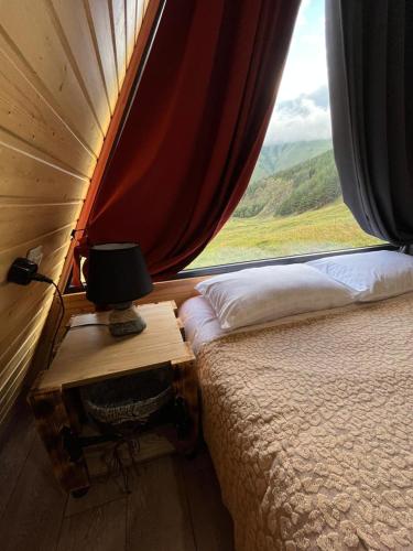a bedroom with a bed and a window with a view at Gudika • გუდიკა in Sno