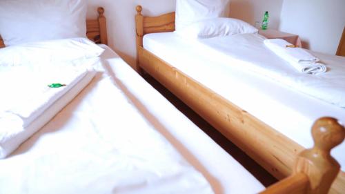 two twin beds in a room with white sheets at Ringhaus - Home of Silver Arrows in Nürburg