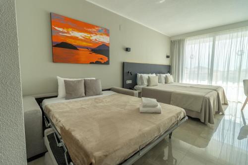 a hotel room with two beds and a painting on the wall at Dos Playas - 30º hotels in Puerto de Mazarrón