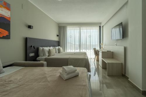 a hotel room with two beds and a window at Dos Playas - 30º hotels in Puerto de Mazarrón