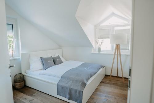 a white bedroom with a bed and a window at City Chalets Salzburg in Salzburg