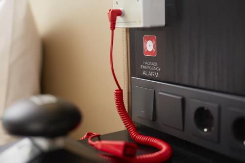 a red corded phone is plugged into a tv at Hilton Tallinn Park in Tallinn