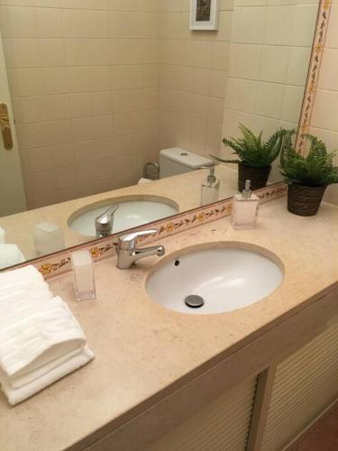 a bathroom counter with a sink and a mirror at Aroeira Golf in Charneca